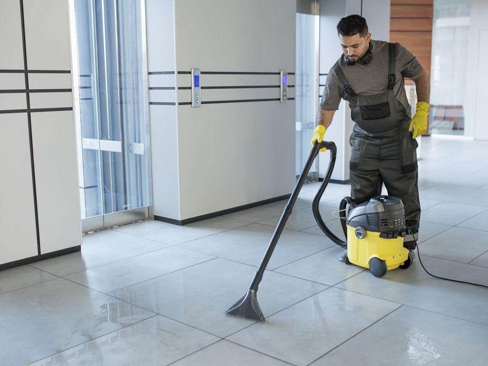 Profissional de limpeza utilizando lavadora de piso em área interna de shopping, reforçando a importância da higienização em espaços comerciais.