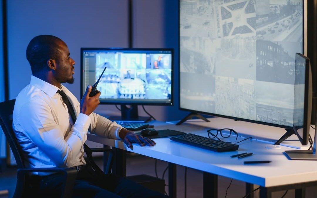 Segurança patrimonial monitorando câmeras de vigilância em sala de controle, garantindo a proteção de patrimônios e áreas restritas.