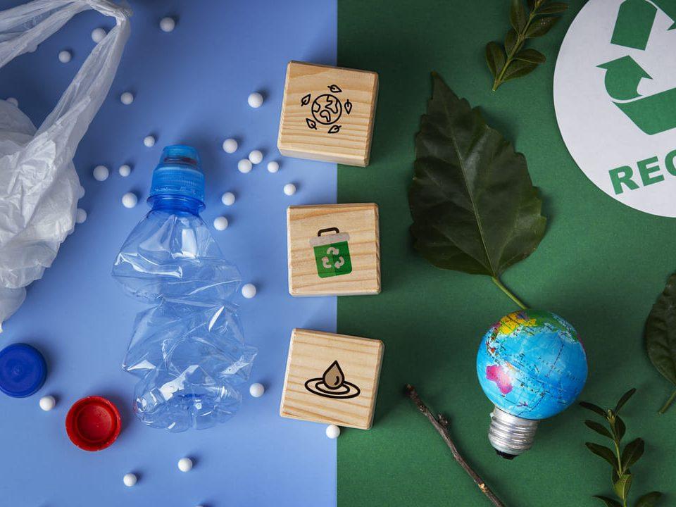 Imagem conceitual sobre sustentabilidade mostrando plástico amassado, blocos com ícones ecológicos, folhas verdes e símbolo de reciclagem, representando os 3 Rs: Reduzir, Reutilizar e Reciclar.
