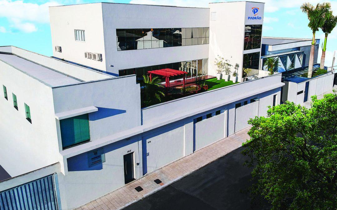 Fachada moderna de uma empresa de facilities, com estrutura limpa, área verde e logo da marca Padrão.