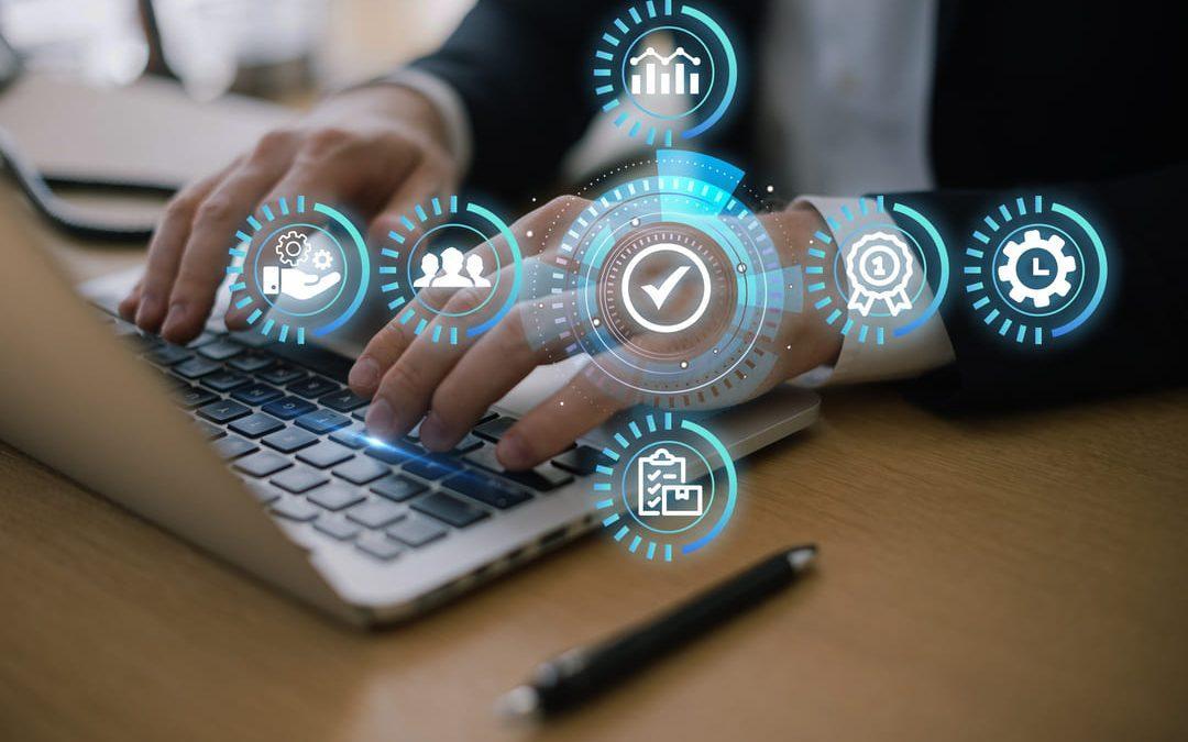 Pessoa digitando em notebook com ícones digitais representando processos de gestão integrada.