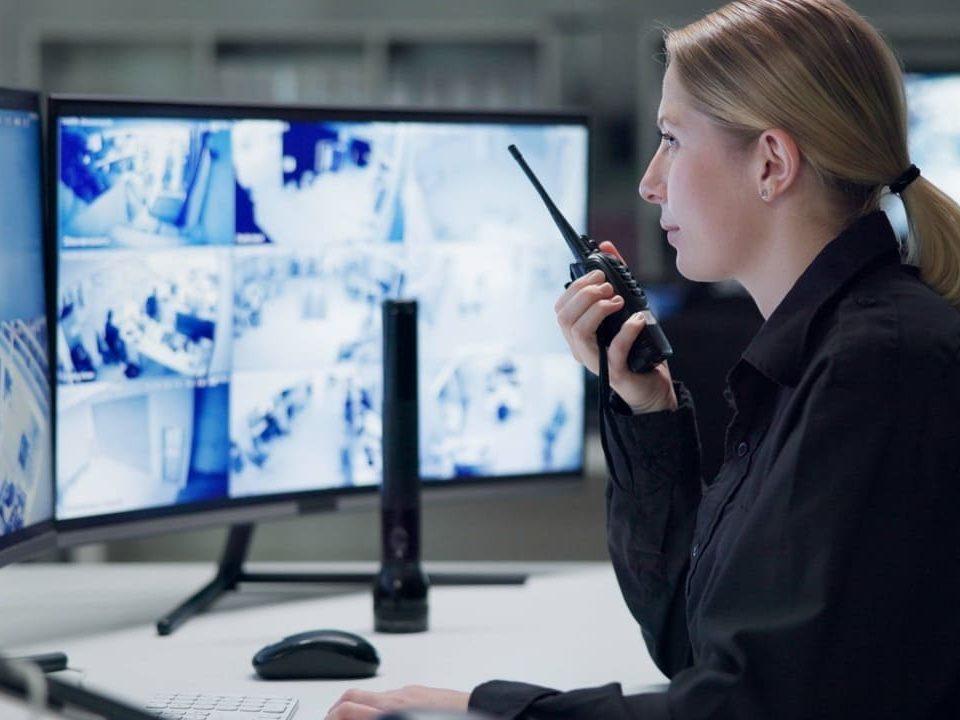 Profissional de segurança monitora câmeras em tempo real, representando a portaria remota em condomínios e empresas.