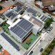 Vista aérea de edifícios com painéis solares instalados nos telhados em área urbana.
