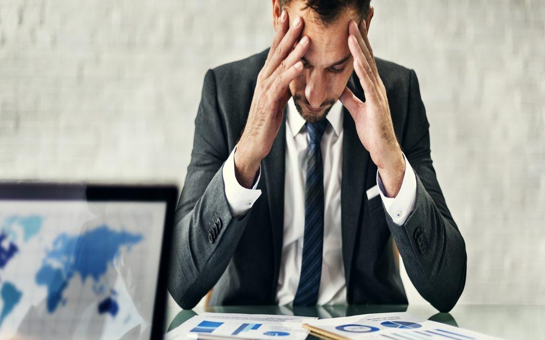 Gestor analisando relatórios com expressão de preocupação, ilustrando como a falta de planejamento pode aumentar o custo operacional e gerar pressão na gestão.