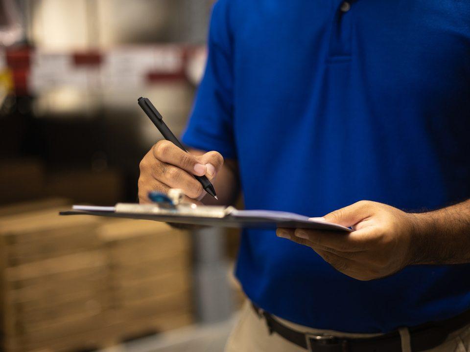 Profissional realizando checklist de controle em ambiente de trabalho, representando processos organizados e excelência operacional na gestão de serviços e rotinas.